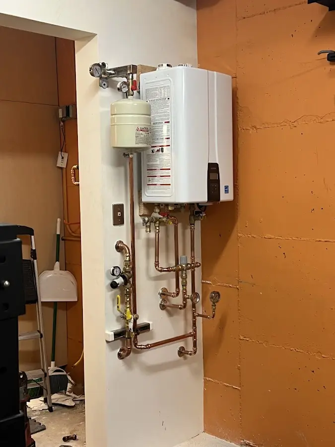 Plumbing technician inspecting water heater connections in Fallston